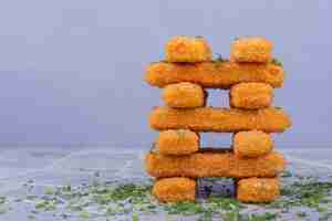 Free photo fried chicken nuggets with crispy topping on blue backgroun.