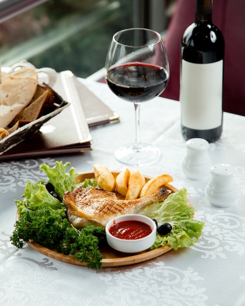 Foto gratuita pollo e patata fritti con vino rosso