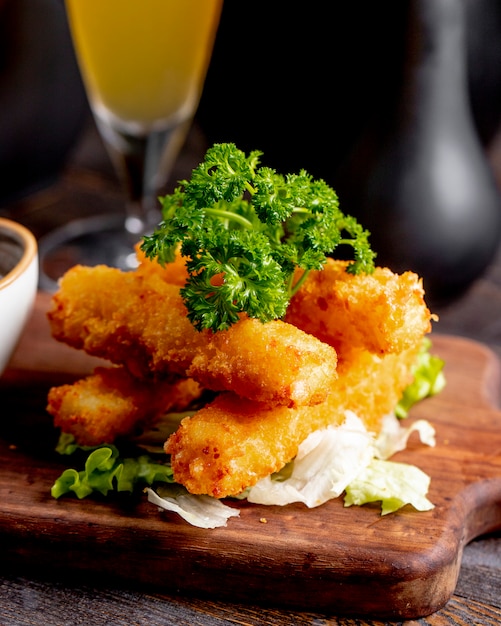 Free photo fried chicken sticks served with lettuce and greens