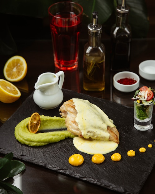 Fried chicken topped with sauce and vegetables in glass