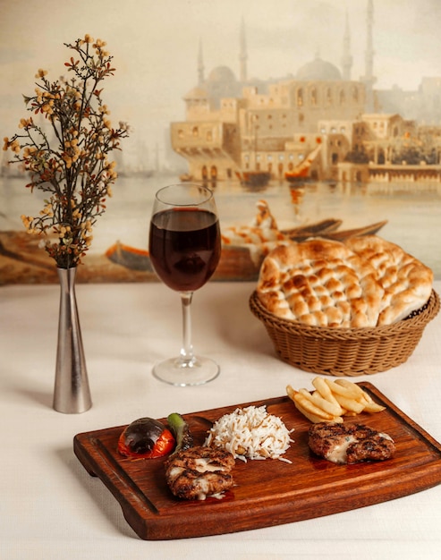 Fried chicken with french fries and rice on wooden board