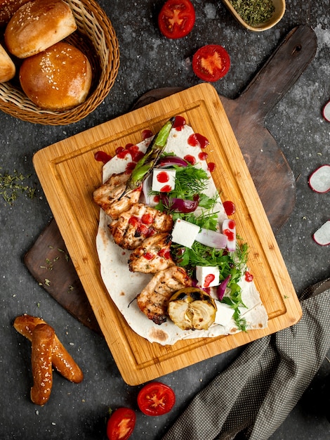 Fried chicken with greens, cheese on a wooden board