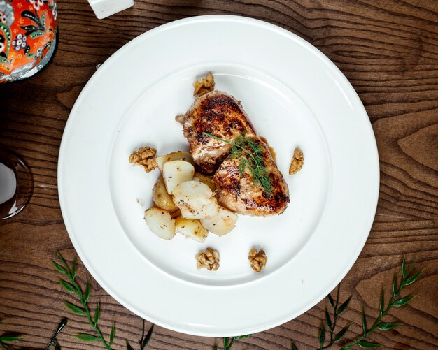 Fried chicken with potatoes in the plate