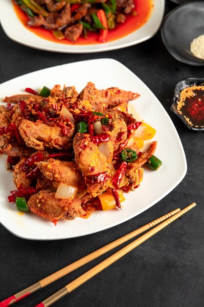  fried chicken with red and green chili peppers and onion on plate