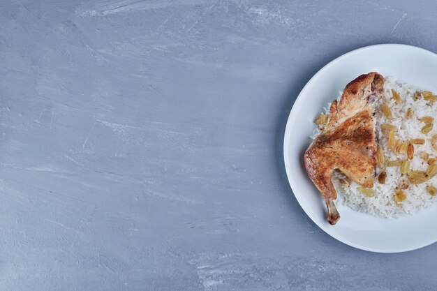 Fried chicken with rice garnish in a white plate.