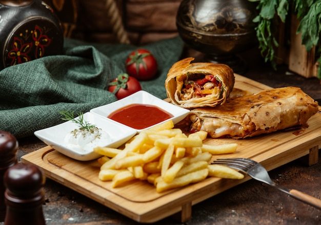 Foto gratuita impacco di pollo fritto con pomodoro, peperoni, patatine fritte, salse