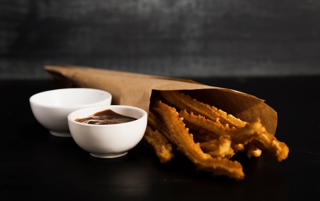 Fried churros with melted chocolate and sugar