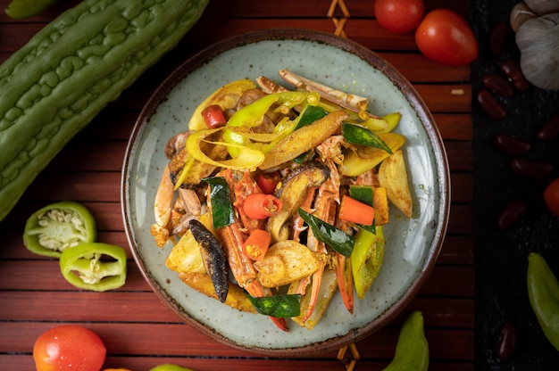 Fried crab with curry powder in a plate with bell peppers and tomatoes.