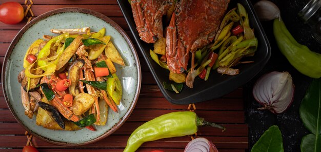 Fried crab with curry powder in a plate with bell peppers and tomatoes.