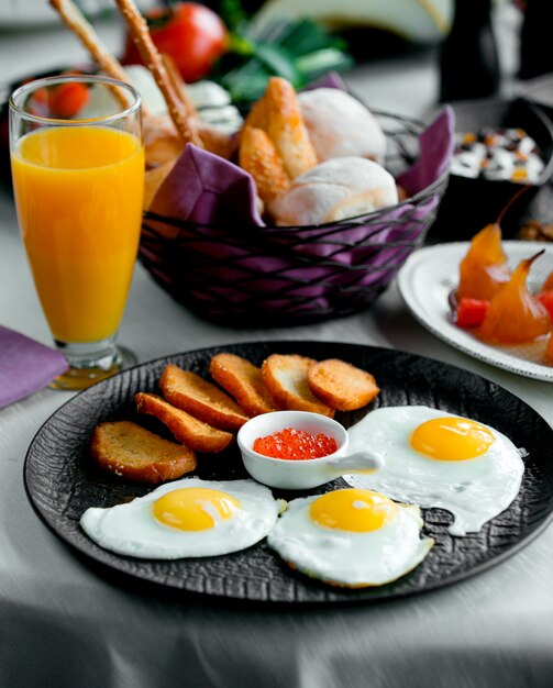 Fried crutones with fried eggs and orange fresh
