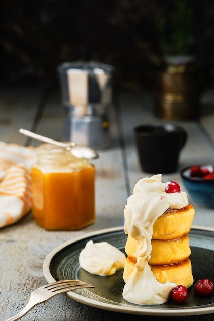 揚げ豆腐パンケーキまたはチーズパンケーキとクリームと蜂蜜と一杯のコーヒー