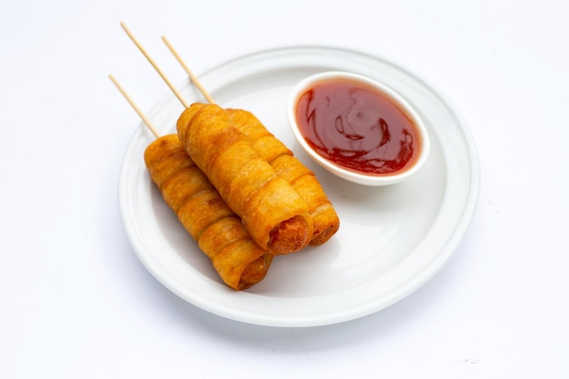 Fried dough snacks wrapped sausage on white background.