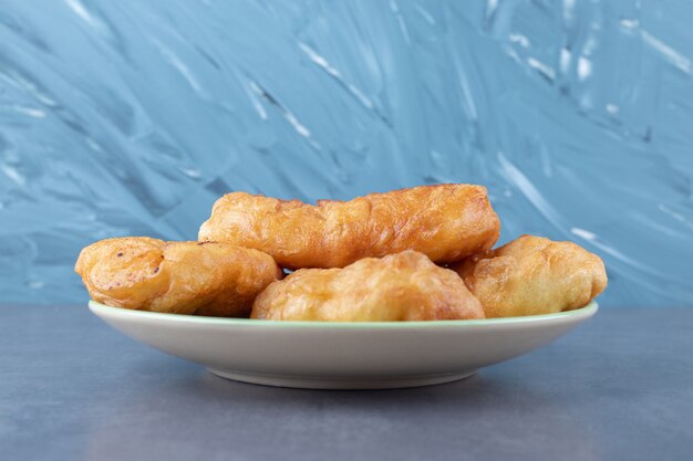 Fried dough stick on plate, on the marble.