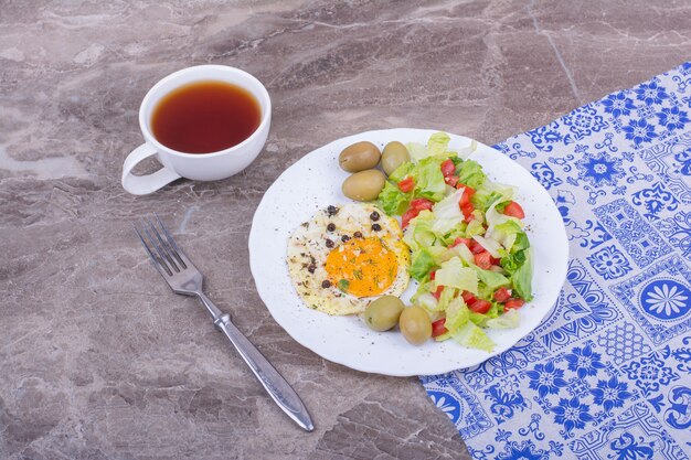 目玉焼きとみじん切りのグリーンサラダとお茶。