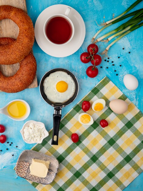 fried egg, tea and tomato on blue table