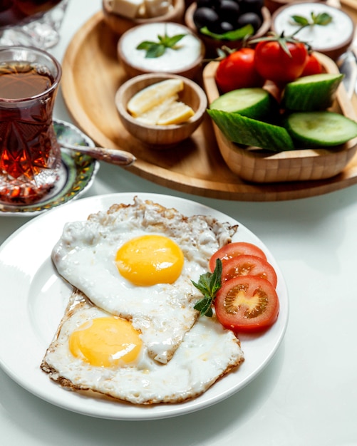 Fried egg with tea and vegetables