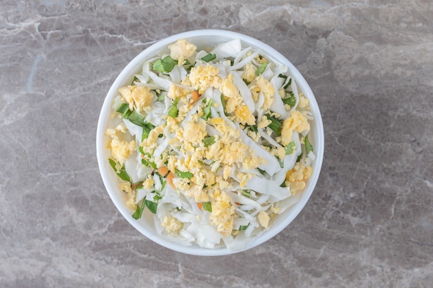 Бесплатное фото Жареные яйца и свежий салат в белой миске.