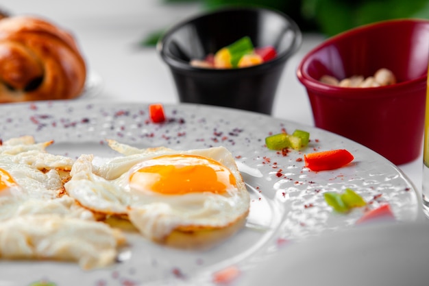 Fried eggs in a plate top view on a pastry on background