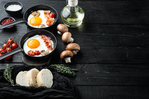 체리 토마토와 빵을 곁들인 튀긴 계란, 아침 식사로 주철 프라이팬, 검정색 나무 테이블 배경, 텍스트 카피스페이스 공간