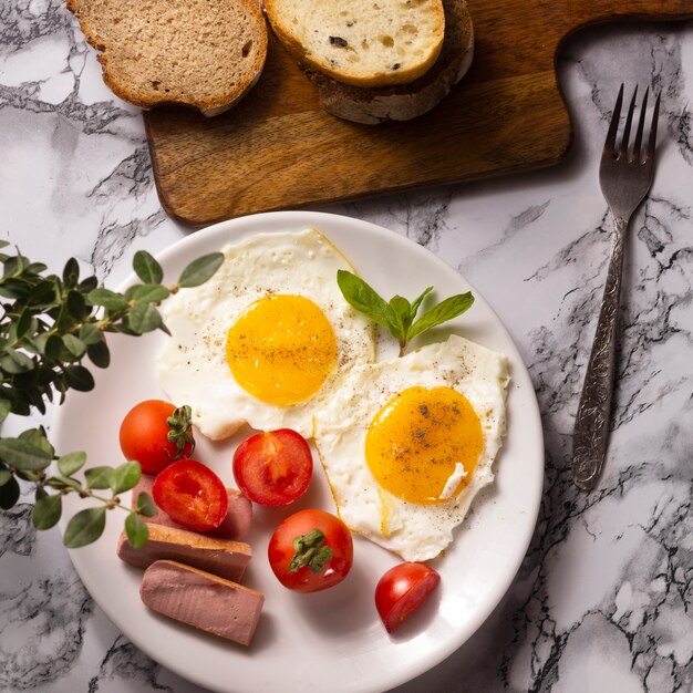 Fried eggs with cherry tomatoes and hotdogs