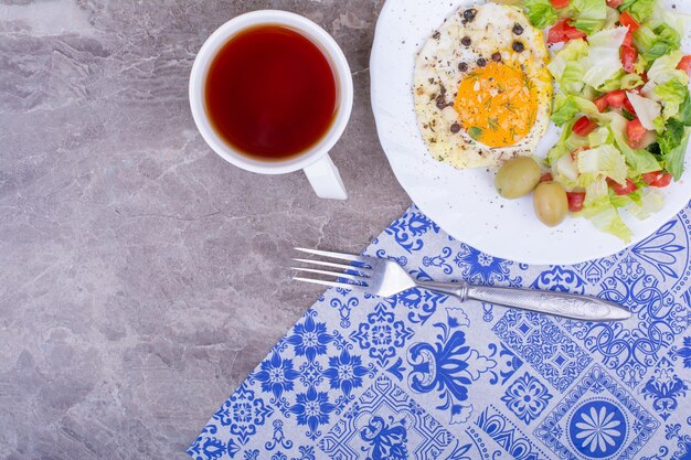 Fried eggs with green salad and a cup of tea.