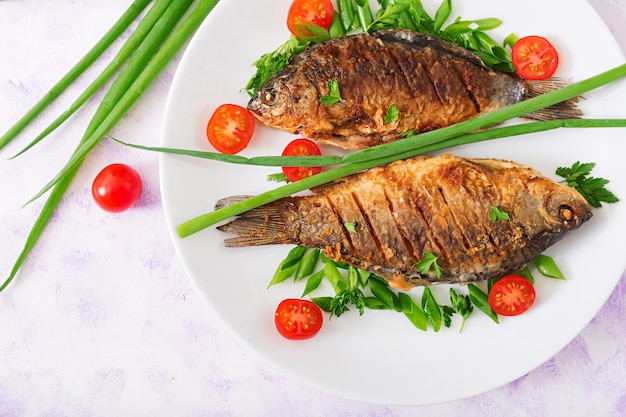 Fried fish carp and fresh vegetable salad. Flat lay. Top view