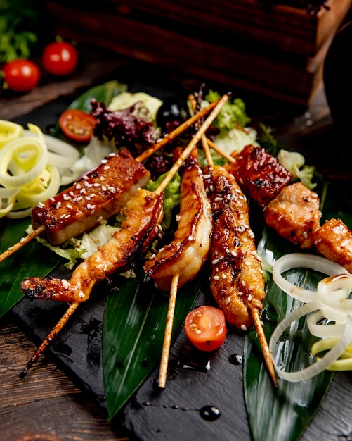 Fried fish and shrimps on sticks served with lettuce tomatoes and onions