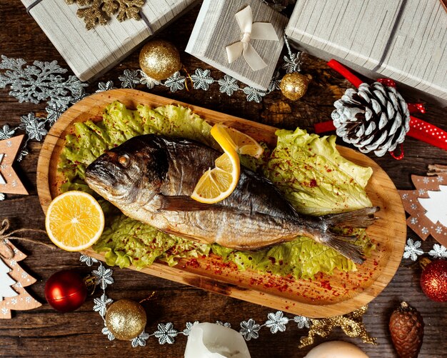 Fried fish topped with pepper and lemon slices