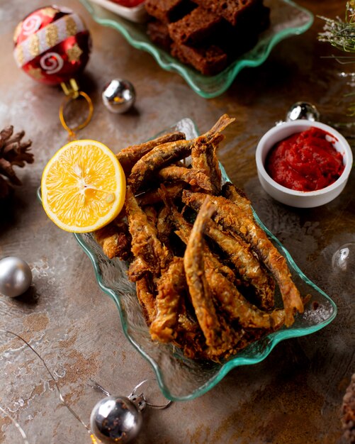 Fried fish with lemon slice and ketchup