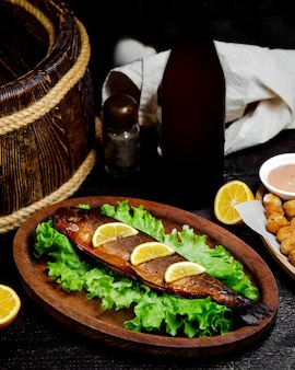 Fried fish with lemon slices on the table
