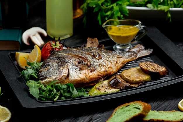 Fried fish with potatoes on furnace board