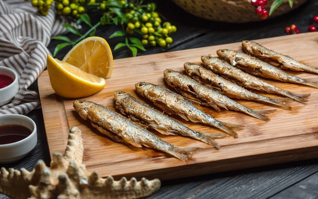Fried fishes set on wooden board