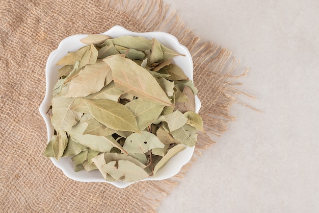 Fried green bay leaves in a ceramic cup.