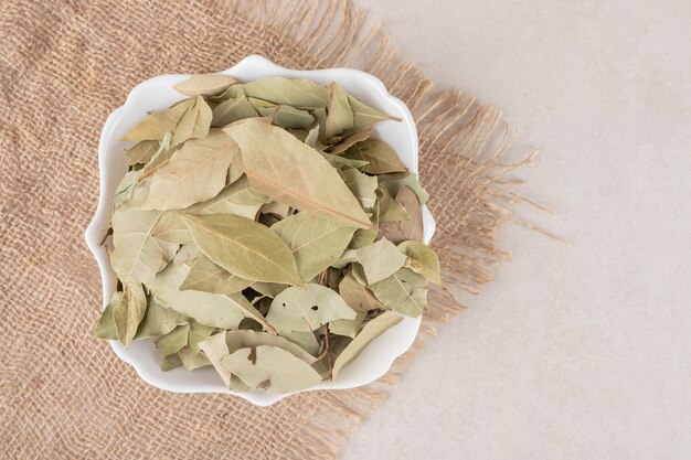 Fried green bay leaves in a ceramic cup.