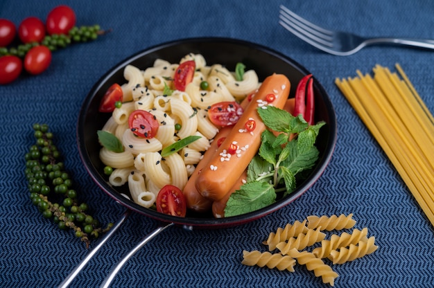 Foto gratuita maccheroni e salsiccia fritti in padella.