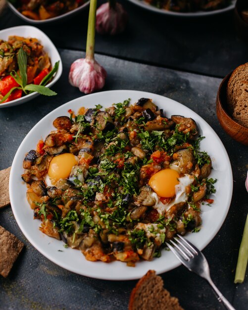 fried meat along with fried vegetables colorful sliced inside white plate along with red wine bread loafs on grey