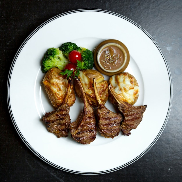 Fried meat ribs with vegetables and potatoes