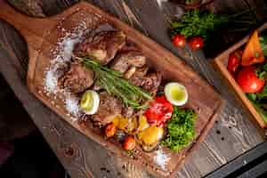 Foto gratuita carne fritta servita con verdure grigliate cipolla e rametto di rosmarino