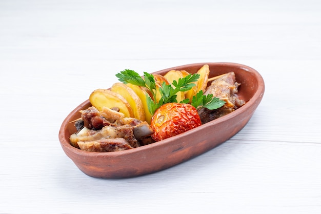 fried meat with greens and baked plums inside brown plate on light desk, food meat dish dinner