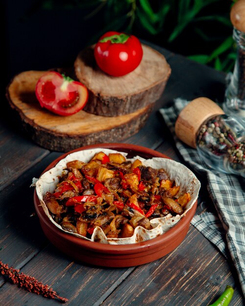 Fried meat with mushrooms and vegetables on the table