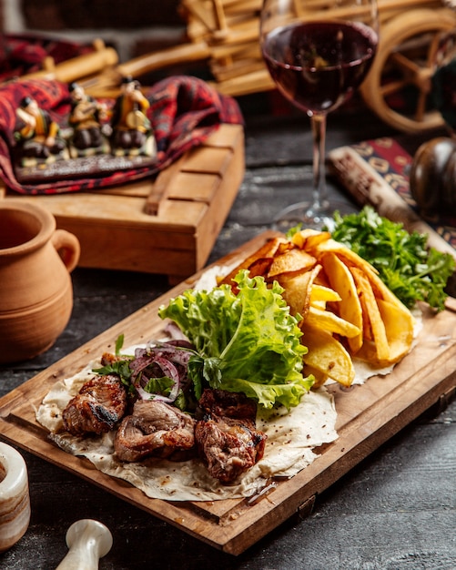 fried meat with potatoes and glass of red wine
