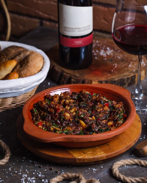 Fried meat with potatoes and greens served with glass of wine