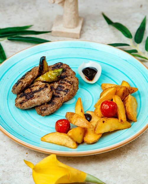 Fried meat with potatoes pepper on the table top view