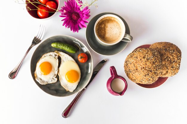 Fried omelette, bread with tea on white backdrop