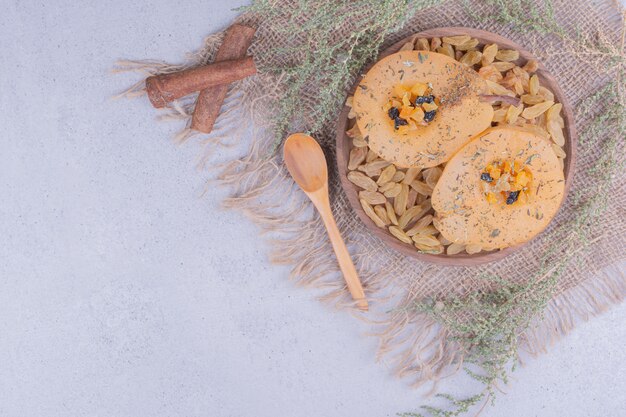 Fried pear slices with spices and sultanas in a wooden platter.