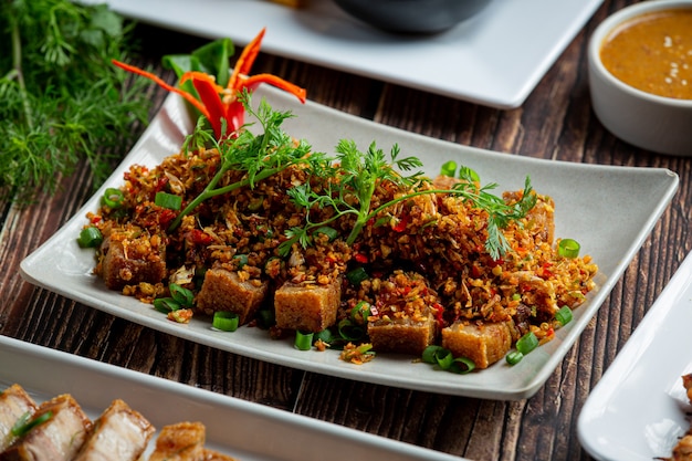 Free photo fried pork with dried chili and salt on dark background