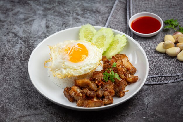 Fried pork with garlic and pepper served with rice and fried egg