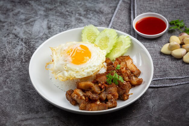 にんにくと胡椒を添えた豚肉の炒め物にご飯と目玉焼きを添えて