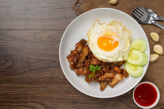 Fried pork with garlic and pepper served with rice and fried egg