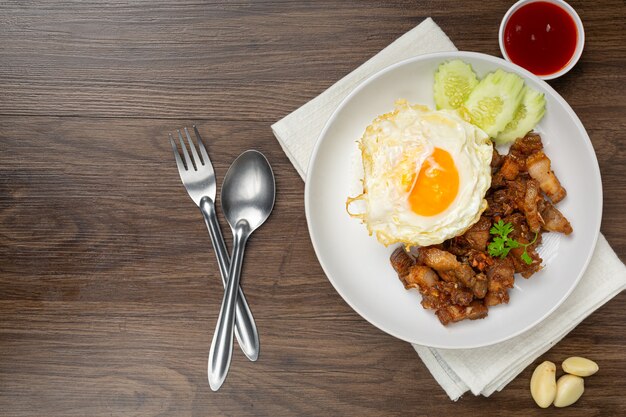 にんにくと胡椒を添えた豚肉の炒め物にご飯と目玉焼きを添えて